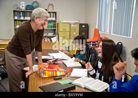 Un enseignant dans une classe d'alphabétisation de base des adultes de la communauté à San Juan Capistrano, California, encourage ses élèves dans leur travail. Banque D'Images