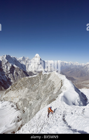 Climber sur crête du sommet de l'Island Peak, 6189m, l'Ama Dablam, 6812m, Région de l'Everest Solu Khumbu, parc national de Sagarmatha (Népal) Banque D'Images