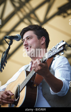 Marcus Mumford du groupe Mumford & Sons joue de la guitare et chante le chant lors de leur concert à l'Eden Project 2010 Banque D'Images