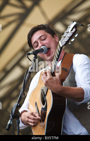 Marcus Mumford du groupe Mumford & Sons joue de la guitare et chante le chant lors de leur concert à l'Eden Project 2010 Banque D'Images