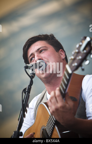 Marcus Mumford du groupe Mumford & Sons joue de la guitare et chante le chant lors de leur concert à l'Eden Project 2010 Banque D'Images