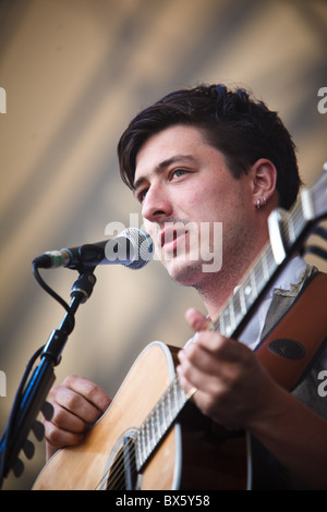 Marcus Mumford du groupe Mumford & Sons joue de la guitare et chante le chant lors de leur concert à l'Eden Project 2010 Banque D'Images