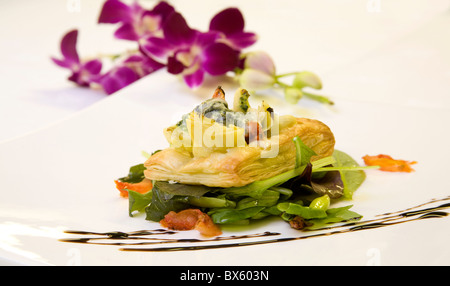 Un fondu gourmet au fromage bleu et pâte d'artichauts sur un lit de salade. Banque D'Images