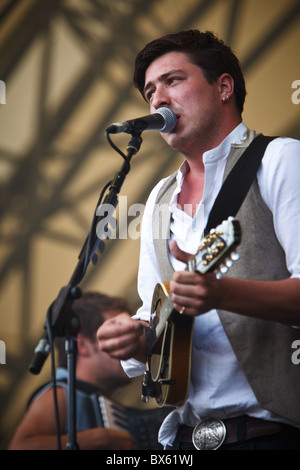 Marcus Mumford du groupe Mumford & Sons joue de la guitare et chante le chant lors de leur concert à l'Eden Project 2010 Banque D'Images