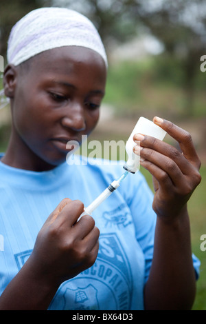 Une femme s'inspire de la médecine une bouteille à Kakata, au Libéria, en Afrique de l'Ouest. Banque D'Images