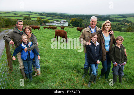 Famille dans l'exploitation dans un champ avec des vaches Banque D'Images