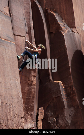 Un alpiniste aborde une fissure surplombante de Indian Creek dans la région de Canyonlands National Park, près de Moab, Utah, USA Banque D'Images