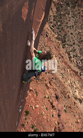 Un alpiniste aborde une fissure surplombante de Indian Creek dans la région de Canyonlands National Park, près de Moab, Utah, USA Banque D'Images