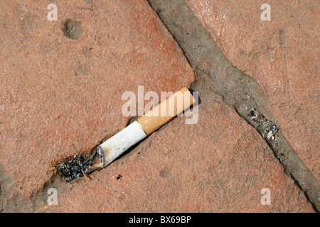 Une cigarette jetée sur fusée street road marbre Banque D'Images