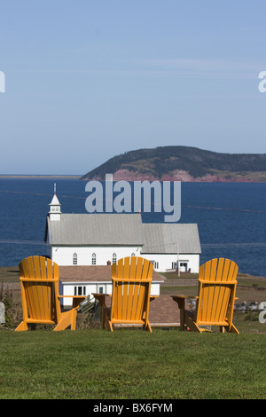 Chaises Adirondack jaune avec vue sur église sur une île dans le golfe du Saint-Laurent, les îles de la Madeleine, Québec, Canada Banque D'Images