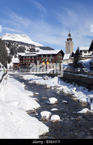 Hotel Krone, rivière et l'église du village, Lech près de St Anton am Arlberg En hiver la neige, Alpes autrichiennes, l'Autriche, Europe Banque D'Images