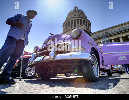 Low angle shot du Capitolio avec voiture américaine classique et vieil homme en premier plan, La Havane, Cuba, Antilles Banque D'Images