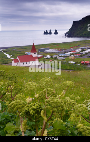 Église et village de Vik Vik (Myrdal) et une mer de Reynisdrangar piles dans la distance, de la côte sud de l'Islande (Sudurland), Islande Banque D'Images