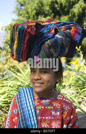 Les textiles à vendre fille transportant sur la tête, le lac Atitlan, Guatemala, Amérique Centrale Banque D'Images