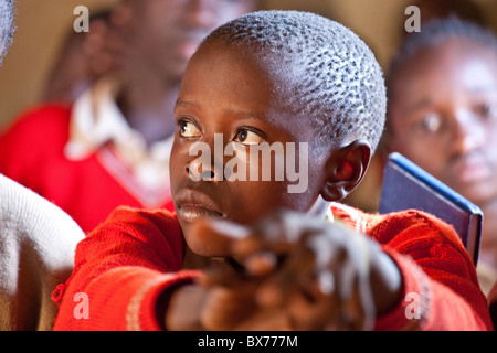 Garçon dans une école primaire classrom dans les bidonvilles de Kibera, à Nairobi, l'Afrique Banque D'Images