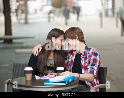 Couple assis à table, faire place au café Banque D'Images