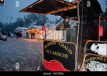 Paris, France, homme vendant des châtaignes chaudes, Teen Street Food Vendor, au marché français de Noël de Paris, sur les champs-Elysées, hiver, travailler la nuit Banque D'Images