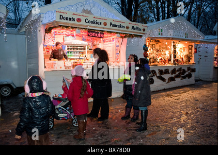 Paris, Rue France, personnes en petit groupe, femmes, achats alimentaires en famille à l'étal de la boulangerie française, marché de Noël, sur les champs-Elysées, nuit, NOËL À PARIS, rue, neige, maman faisant du shopping avec sa fille Banque D'Images