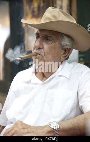 Fumer un cigare cubain emigre portant un chapeau de cow-boy dans la Calle Ocho, Miami, Floride, États-Unis d'Amérique, Amérique du Nord Banque D'Images