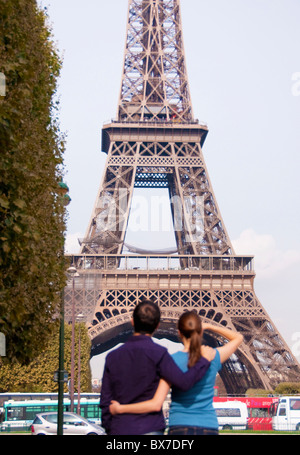 Couple regarde tour Eiffel à Paris Banque D'Images