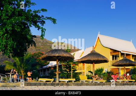 Les clients peuvent profiter d'un coucher de soleil sur la plage et le jardin à un hôtel à la preneuse, Rivière Noire, Ile Maurice. Banque D'Images