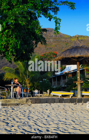 Les clients peuvent profiter d'un coucher de soleil sur la plage et le jardin à un hôtel à la preneuse, Rivière Noire, Ile Maurice. Banque D'Images