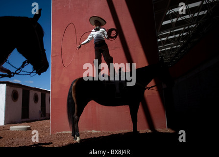 Une jeune Mexicaine charro pratiques avec son lasso comme il se tient sur son cheval au Championnat National Charro à Pachuca, Mexique Banque D'Images