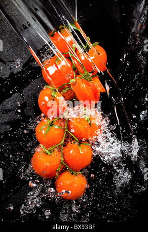 Branche de tomates dans les projections d'eau Banque D'Images