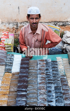 L'homme musulman d'épices vente en paquets à un marché de l'Inde, l'Andhra Pradesh. L'Inde Banque D'Images