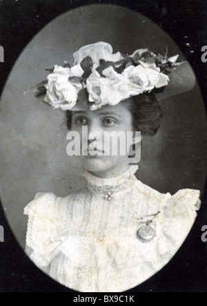 Jeune femme portant un plateau de la période victorienne de style édouardien hat Americana fleurs mode noir et blanc portrait féminin d'usure de la tête Banque D'Images