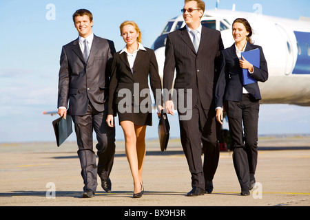 Groupe de personnes réussies marche sur le fond de l'avion Banque D'Images