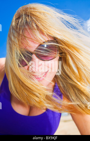 Femme souriante sur une plage de vent Banque D'Images