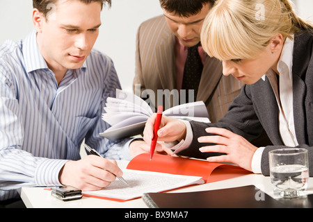 Portrait des gens d'affaires pointant sur un texte d'un document de travail Banque D'Images