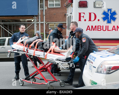 Les premiers intervenants déposer un cycliste dans une ambulance après avoir été frappé par un autobus à New York Banque D'Images