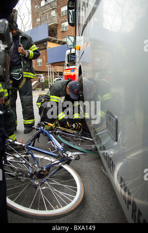 Les premiers intervenants déposer l'endommagement d'un cycliste après qu'il a été frappé par un autobus à New York Banque D'Images