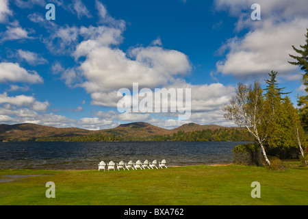 Chaises blanches sur le rivage de Blue Mountain Lake dans les montagnes Adirondack de New York Banque D'Images