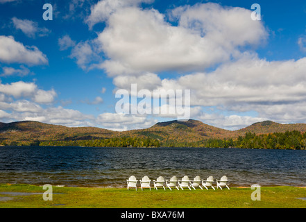 Chaises blanches sur le rivage de Blue Mountain Lake dans les montagnes Adirondack de New York Banque D'Images