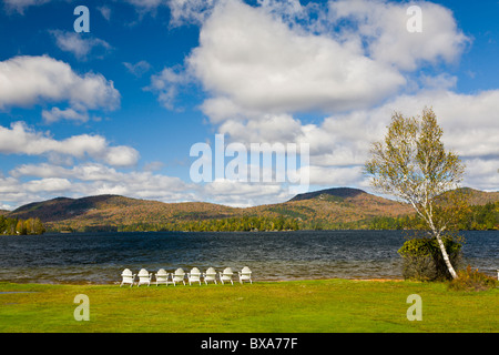 Chaises blanches sur le rivage de Blue Mountain Lake dans les montagnes Adirondack de New York Banque D'Images