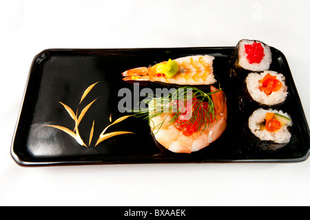 Norimaki sushis avec une crevette enroulé autour d'œufs de saumon, l'aneth et sauce wasabi. Sur blanc. Banque D'Images