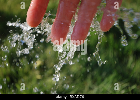 L'eau froide et la main sur fond vert. Banque D'Images