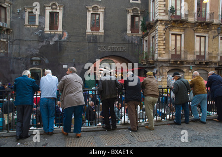 Les hommes à regarder l'action de la Pescheria le marché des fruits de mer centre de Catane Sicile Italie Europe Banque D'Images