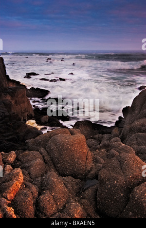 Détails de les vagues se briser sur la plage de l'océan Pacifique rocheuses avec les détails de la roche et le ciel au lever du soleil Banque D'Images