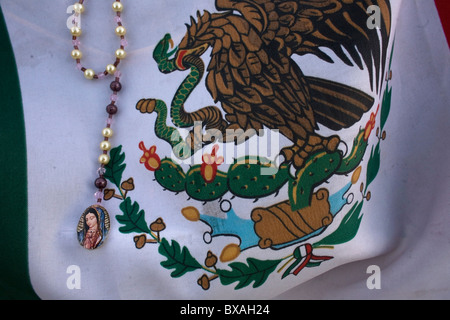 Un chapelet avec l'image de Notre Dame de Guadalupe décore un drapeau mexicain à Mexico Banque D'Images