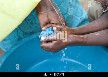 Un garçon se lave les mains à Iganga, est de l'Ouganda, l'Afrique de l'Est. Banque D'Images