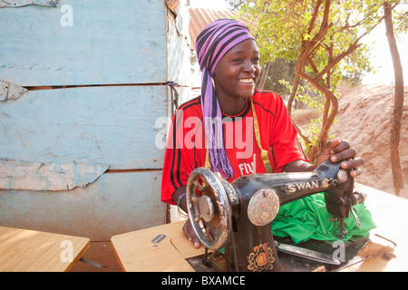 Un Mbawaire sur mesure (Amina) à sa machine à coudre à Iganga, est de l'Ouganda, l'Afrique de l'Est. Banque D'Images