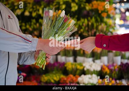 Femme de payer pour le bouquet de fleurs Banque D'Images