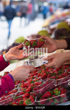 Femme de payer pour panier de fraises Banque D'Images