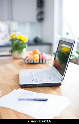 Ordinateur portable sur une table de cuisine Banque D'Images