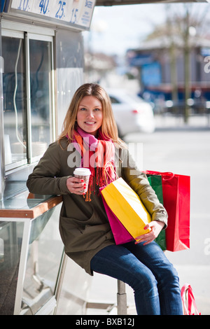 Jeune femme prendre de pause shopping, boire du café à emporter Banque D'Images