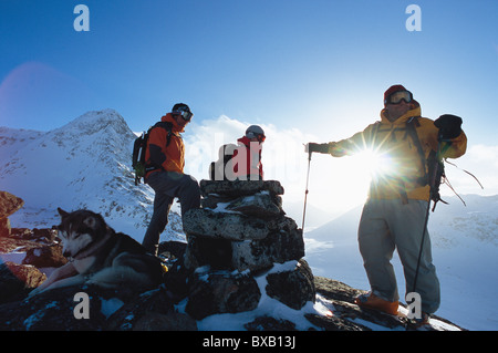Partie de randonneurs avec chien sur le dessus de la montagne en hiver Banque D'Images